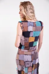 Musculosa de cuello redondo con volados en las sisas y diseño estampado de bloques estilo patchwork en tonos marrones, blancos, celestes y violetas.