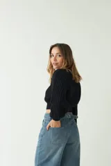 Sweater tejido de punto grueso color crema, con textura chunky, corte cropped, mangas abullonadas y puños ajustados.