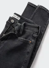 Jeans de corte skinny y tiro alto, confeccionados en tejido denim elástico de algodón. Presentan diseño clásico de cinco bolsillos, trabillas para cinturón y cierre frontal con cremallera y botón.