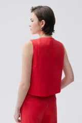 Chaleco rojo de lino con botones de carey en el frente y calce recto.