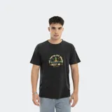 Remera negra de corte oversize con estampado de palmeras y piñas.