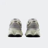 Championes urbanos New Balance modelo 9060, color gris con detalles en verde y blanco, confeccionados en gamuza y malla, con logo "N" característico en los laterales y entresuela con amortiguación ABZORB y SBS.