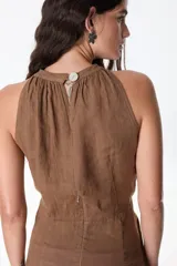 Vestido corto de lino celeste, con escote halter, falda drapeada asimétrica y cierre invisible en el lateral.