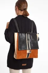 Mochila de cuero vacuno color marrón, con detalles en cuero charol color beige y cuero con textura de cocodrilo color negro. Tiene correas ajustables, cierre interior, dos bolsillos internos (uno con cierre y otro para celular), sujetador de llaves y mosquetón de seguridad externo. Se puede usar como mochila o como cartera.