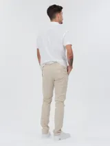 Pantalón chino color beige de corte slim y pierna recta, confeccionado en sarga de algodón elástico.