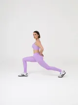 Legging deportiva de tiro alto, color lila, con diseño de costuras anatómicas que brindan ajuste y soporte muscular.