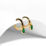 Par de aros dorados tipo argolla, con dije colgante en forma de lágrima con piedra verde esmeralda.
