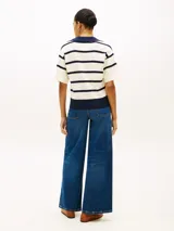 Chomba de punto Tommy Hilfiger de corte amplio, con diseño de rayas horizontales blancas y azul marino, manga corta, hombros caídos y cuello en V con solapa.