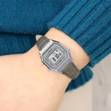 Reloj digital Casio estilo vintage con caja plateada de 28mm y correa de cuero gris con textura de cocodrilo. Cuenta con pantalla digital, funciones de cronómetro, alarma y calendario.