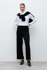 Pantalón tejido de corte recto y tiro alto, color negro con detalles de líneas laterales en tono beige. Posee cintura elástica para mayor comodidad.