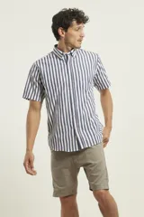 Camisa de manga corta con estampado de rayas verticales en azul y blanco, cuello abotonado y bolsillo frontal en el pecho.