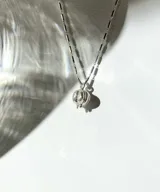 Collar plateado con dije en forma de pitanga.