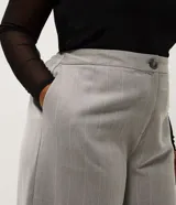 Pantalón de sastre con estampado de cuadros, corte wide leg de cintura alta y caída recta. Cuenta con cierre frontal de botón y cremallera.