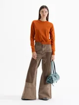 Sweater de tejido de punto color naranja, con cuello redondo, mangas largas y puños acanalados. Presenta una textura suave y un diseño clásico de calce estructurado.