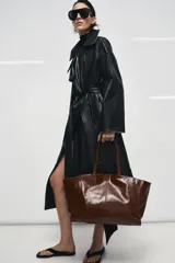 Bolso tipo shopper confeccionado en piel, con diseño de doble asa de hombro y cierre mediante botón imantado. Incluye bolsillo interior.