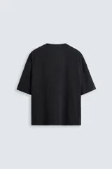 Camiseta gris de corte cuadrado y holgado, con cuello redondo y mangas cortas.