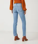 Pantalón de jean modelo slim con cintura mediana, trabillas para cinturón y bolsillos funcionales. Presenta un diseño clásico con acabado en el bajo.