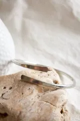 Pulsera rígida abierta de alpaca color plateado, con extremos planos.