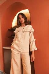 Pantalón palazzo color coral de lino con cintura alta y bolsillos laterales.