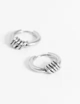 Aros de acero quirúrgico hipoalergénico tipo argolla plateada, con diseño minimalista y elegante.