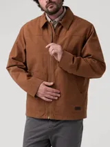 Chaqueta de canvas color marrón, con cierre frontal completo, cuello clásico y forro interior de sherpa. Presenta dos bolsillos frontales tipo parche y corte regular.