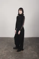 Camiseta negra de cuello alto y mangas largas con paneles de tul transparente en mangas y espalda.