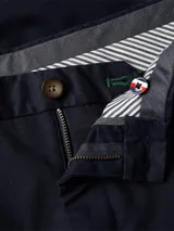 Pantalón chino azul marino de sarga en mezcla de algodón orgánico, corte regular, cierre de cremallera con botón y detalles distintivos de Tommy Hilfiger.