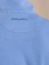 Sweater celeste de algodón y poliéster con cuello alto y cierre parcial con cremallera.
