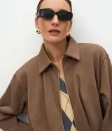 Campera corta de algodón con felpa, diseño tipo baloné con cuello clásico y cierre frontal de cremallera metálica. Presenta un corte holgado y estructura uniforme.