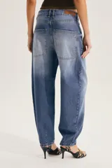 Jean slouchy de tiro alto color crudo, con silueta relajada tipo barrel que se afina hacia los tobillos.