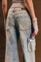 Pantalón cargo de denim celeste con efecto acid wash, corte ancho y múltiples bolsillos con solapa en los laterales y a la altura de las pantorrillas.