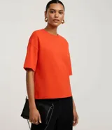 Blusa basica oversize de algodon color marron, con cuello redondo y mangas cortas con sisas desplazadas.