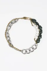 Collar de diseño asimétrico compuesto por una combinación de cadenas de eslabones plateados, una cadena de esferas metálicas doradas y una sección con cuentas de resina en tonos verde oscuro y blanco traslúcido. Presenta un cierre tipo T en la parte superior.
