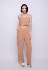 Pantalón color ocre de corte ancho, con pinzas, bolsillos cargo laterales, presillas, cierre y tres botones.