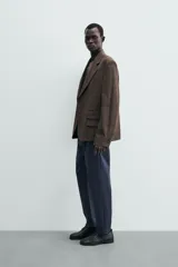 Pantalón chino de corte regular fit, confeccionado en tejido de algodón con elasticidad. Presenta bolsillos frontales, bolsillos traseros de vivo y cierre frontal con cremallera y botón.