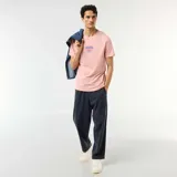 Camiseta rosada de manga corta y cuello redondo, con estampa frontal centrada con el texto "CASA VERDE Club Crafted Cocktails" en tonos azules y rojos.