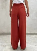 Pantalón celeste de lino con corte palazzo, tiro alto y botón a la vista.