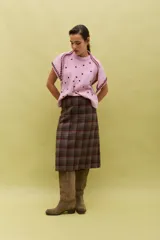 Falda midi de corte recto con estampado de cuadros en tonos tierra y líneas en contraste. Presenta un diseño estructurado y elegante, confeccionada en tejido de lana con forro interior.