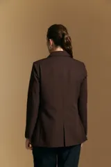 Blazer de corte sastrero con solapas clásicas y estructura definida. Presenta un diseño versátil con silueta ligeramente oversized, ideal para un estilo sofisticado y atemporal.