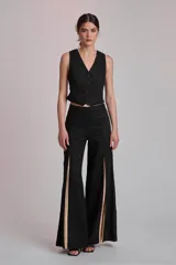 Chaleco sastrero negro con escote en V y cierre frontal con botones a tono. Presenta un corte entallado y diseño corto.