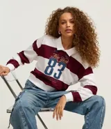 Blusa de malla de algodón con cuello de solapa y mangas largas. Tiene patrón de rayas bold y estampa delantera con lettering sportcore.