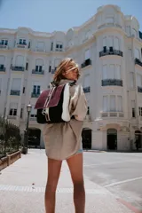 Mochila de cuero vacuno color negro, con tapa de cuero con textura croco color bordó y detalles en blanco. Tiene mosquetón de seguridad exterior, cierre interior, dos bolsillos interiores (uno con cierre y otro para celular), sujetador de llaves, forro completo y tiras ajustables. Se puede usar como mochila o como cartera.