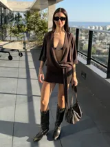 Vestido corto marrón con escote pronunciado en V, mangas murciélago y faja integrada para atar en la cintura.