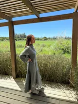 Vestido largo color verde oliva, de lino, con corte amplio, cuello mao, escote en V y mangas largas acampanadas.