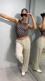Pantalon de tiro bajo con cordón ajustable en la cintura, confeccionado en tela brillante con textura acanalada, de corte recto y holgado.