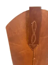 Bota de caña alta color negro, estilo biker, confeccionada en cuero engrasado con detalle de estribo con hebilla.