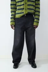 Pantalón de jean negro de corte amplio estilo skater, con tiro medio, cierre de botón y cremallera, y diseño clásico de cinco bolsillos.