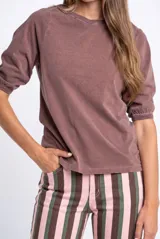 Remera de algodón lavado gris oscuro, con cuello redondo y mangas cortas abullonadas estilo globo con puños fruncidos.