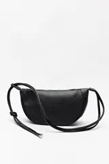 Cartera tipo bandolera negra de símil cuero, con formato alargado y correa regulable con nudos.