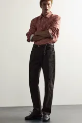 Jeans straight fit de corte recto y tiro medio, confeccionados en denim de algodón con efecto lavado en color marrón oscuro, con diseño clásico de cinco bolsillos y cierre frontal con botonadura.